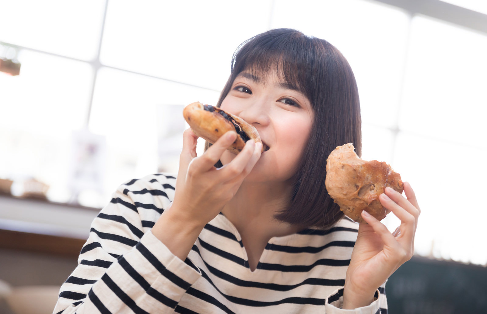 おいしそうにパンを食べる女性